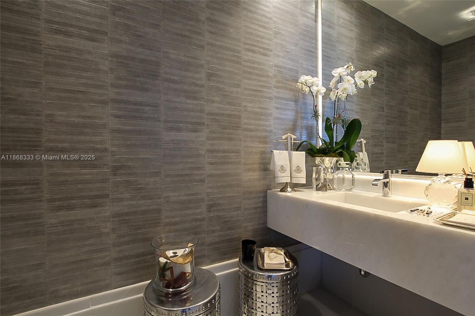 18555 Collins Avenue, Unit 4605 Sunny Isles Beach, FL 33160 - Photo 25 of 40 a bathroom with a sink a toilet and a mirror