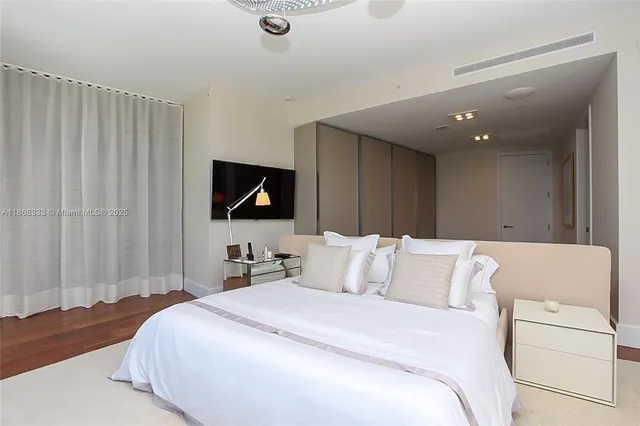a bedroom with a bed and a flat screen tv