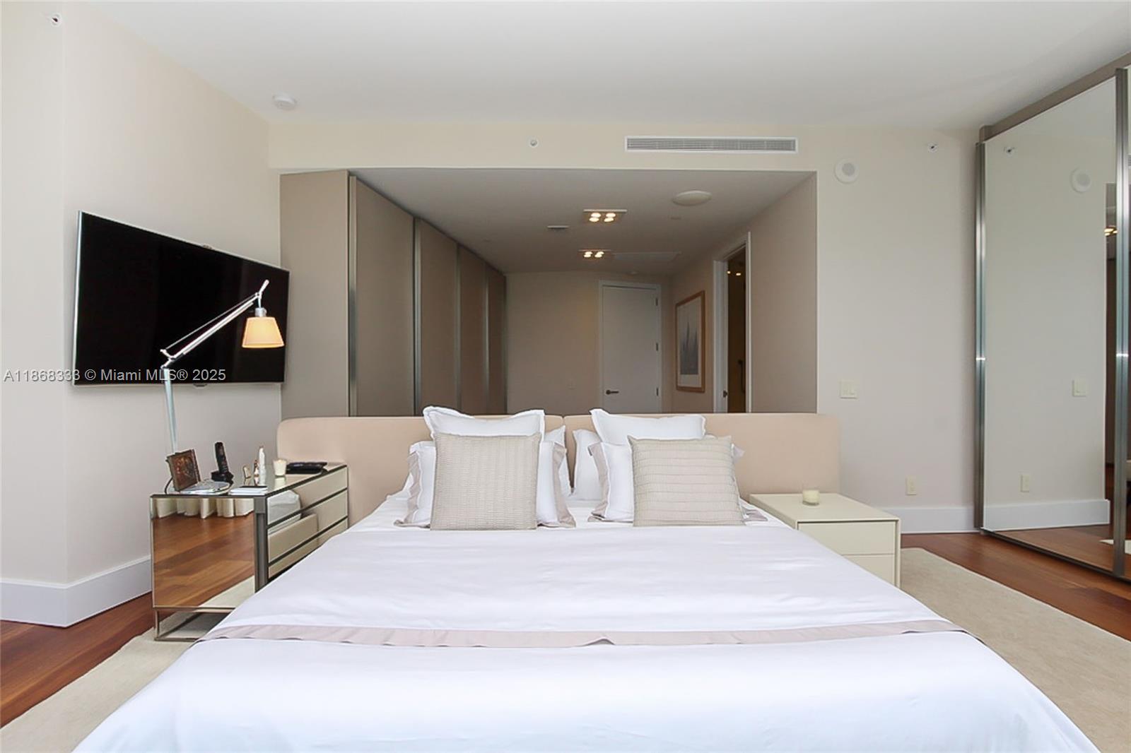 18555 Collins Avenue, Unit 4605 Sunny Isles Beach, FL 33160 - Photo 27 of 40 a bedroom with a bed and a flat screen tv