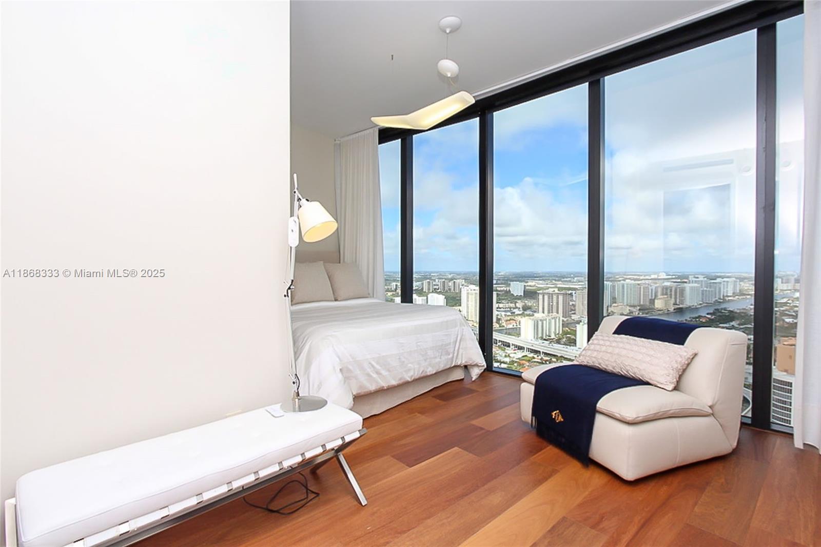 18555 Collins Avenue, Unit 4605 Sunny Isles Beach, FL 33160 - Photo 33 of 40 a bedroom with furniture and a large window