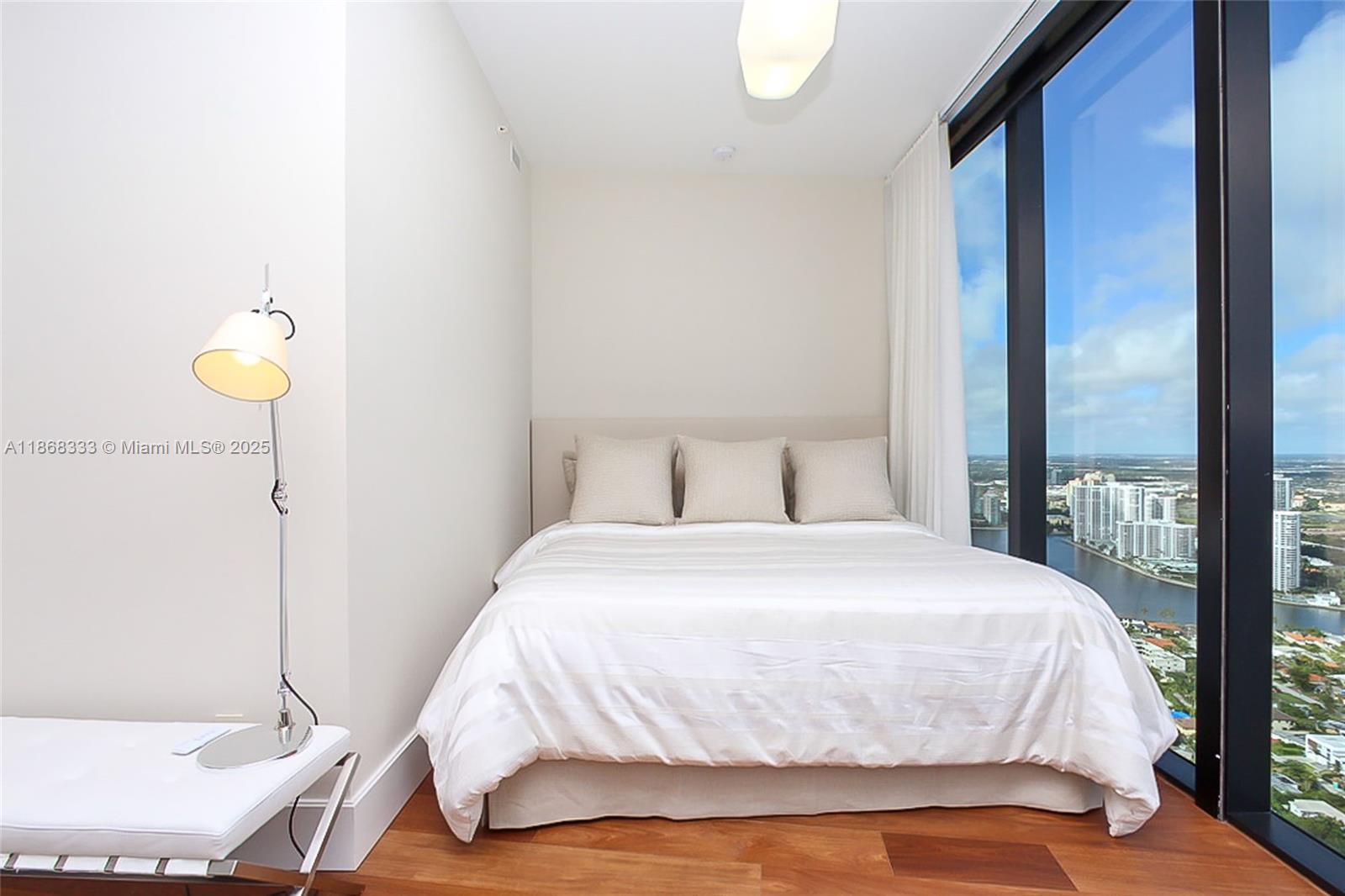 18555 Collins Avenue, Unit 4605 Sunny Isles Beach, FL 33160 - Photo 34 of 40 a bedroom with a bed and painting on the wall