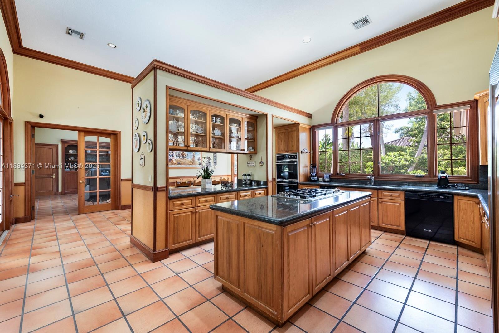 9360 Southwest 66th Street Miami, FL 33173 - Photo 16 of 64 a kitchen with stainless steel appliances granite countertop a stove a sink and a dining table