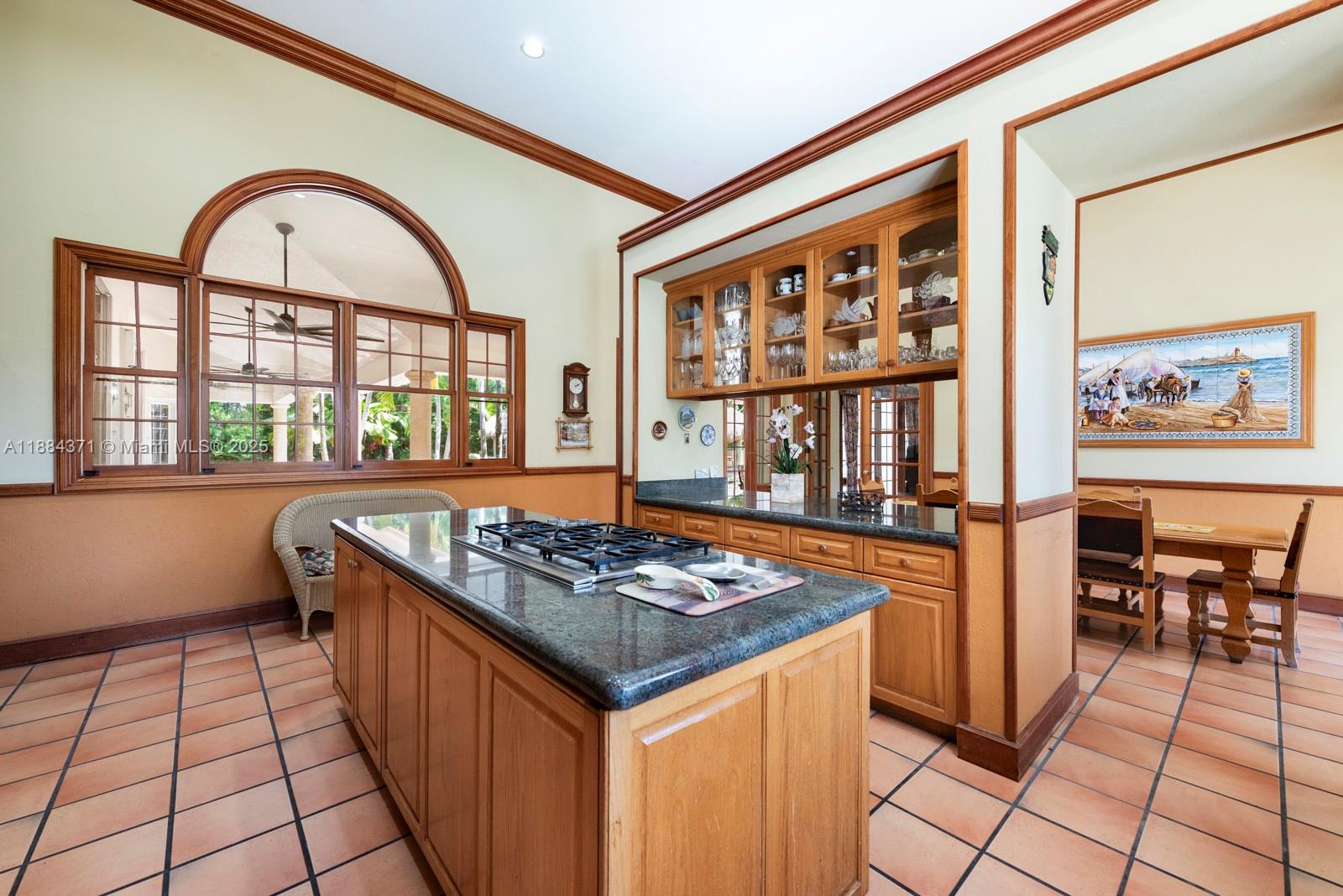 9360 Southwest 66th Street Miami, FL 33173 - Photo 18 of 64 a kitchen with stainless steel appliances granite countertop a stove a sink and a dining table with wooden cabinet