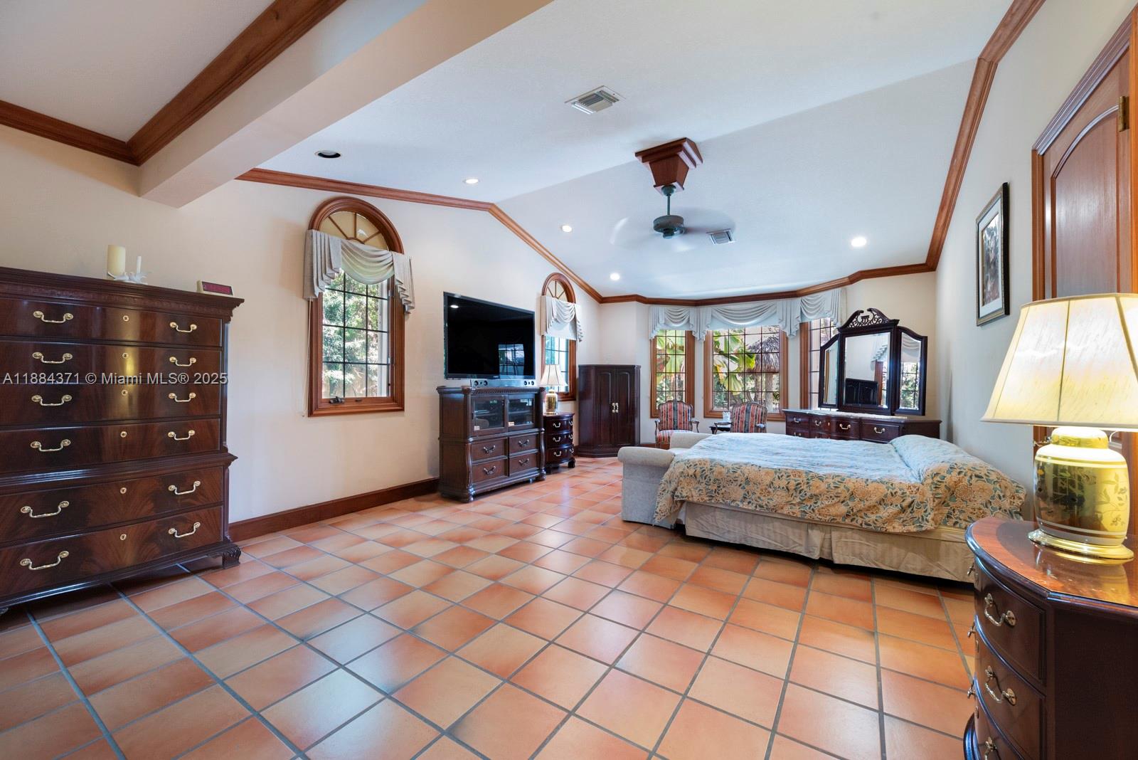 9360 Southwest 66th Street Miami, FL 33173 - Photo 23 of 64 a spacious bedroom with a bed and a flat screen television
