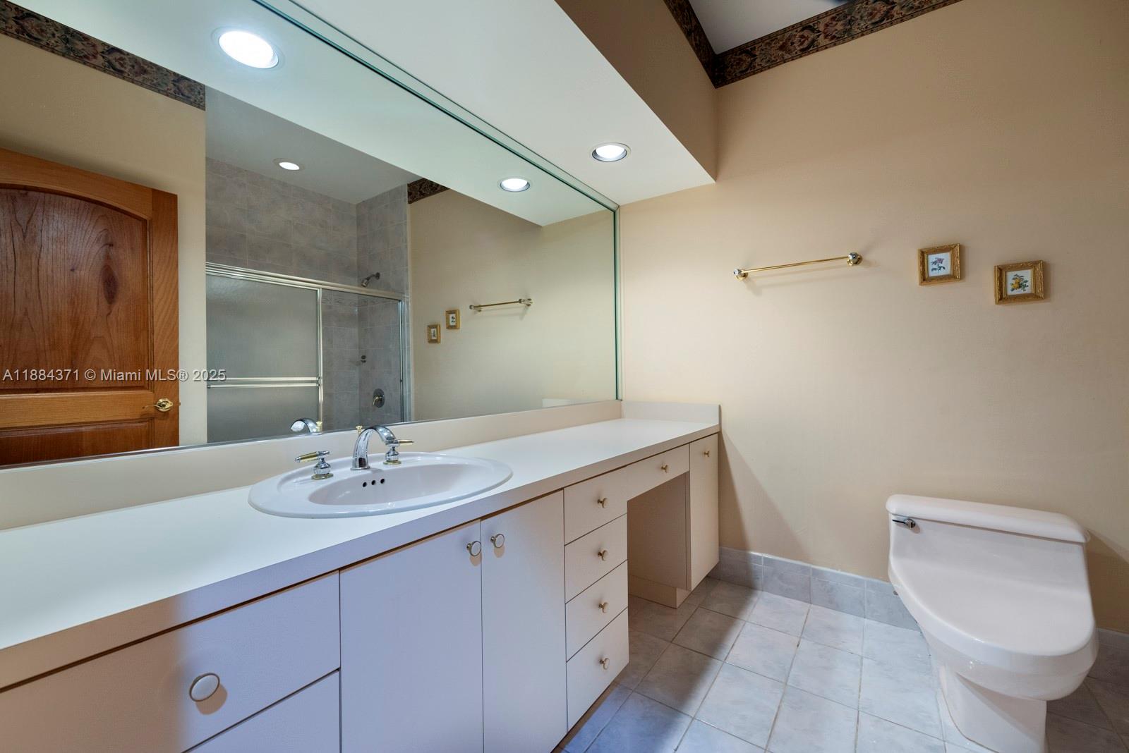 9360 Southwest 66th Street Miami, FL 33173 - Photo 39 of 64 a bathroom with a sink a toilet and a mirror