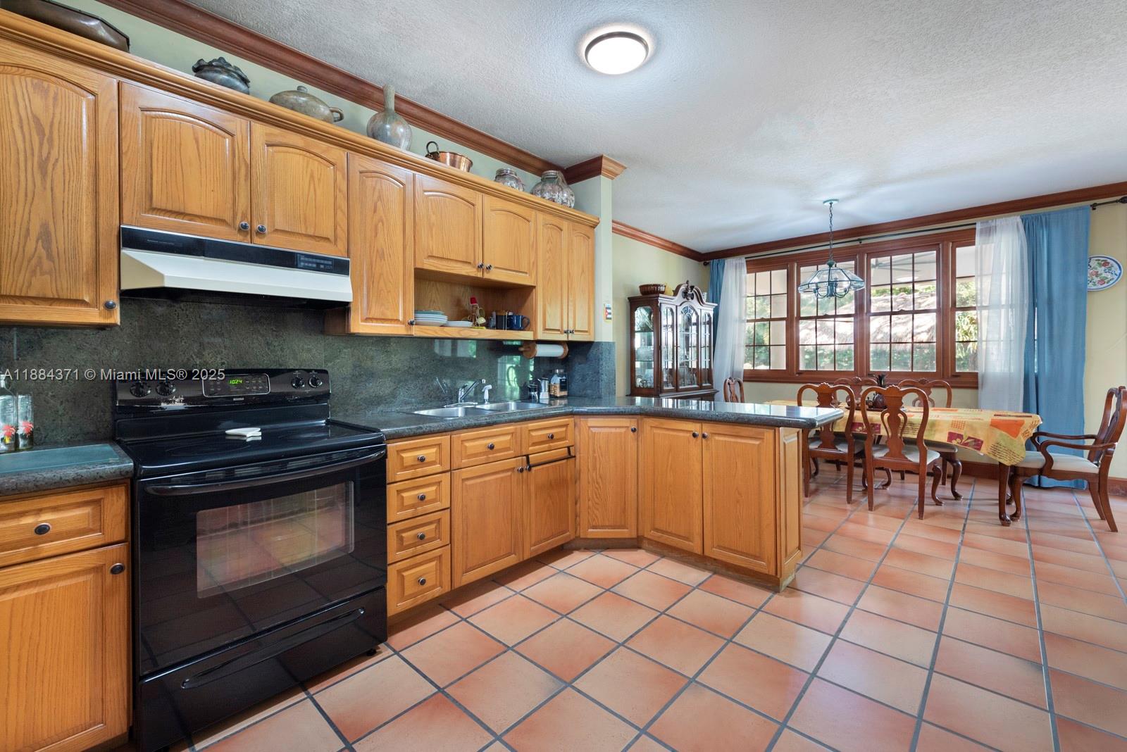 9360 Southwest 66th Street Miami, FL 33173 - Photo 44 of 64 a kitchen with stainless steel appliances granite countertop a stove a sink and a microwave