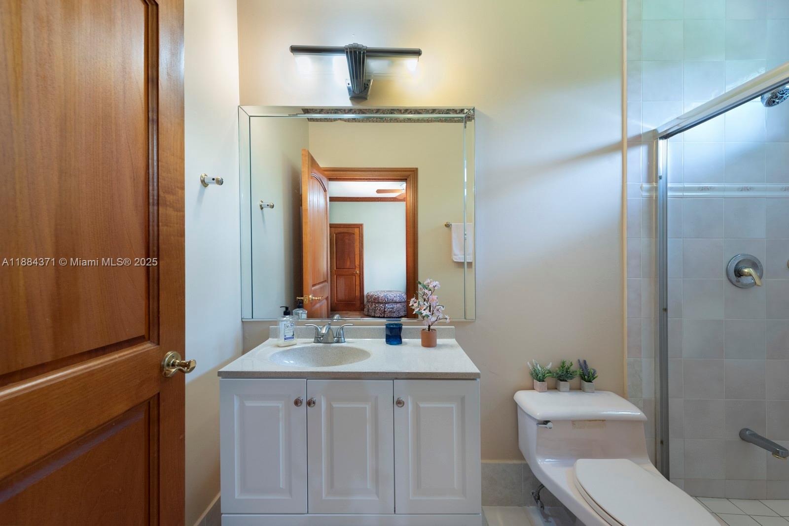 9360 Southwest 66th Street Miami, FL 33173 - Photo 47 of 64 a bathroom with a toilet a sink a mirror and vanity