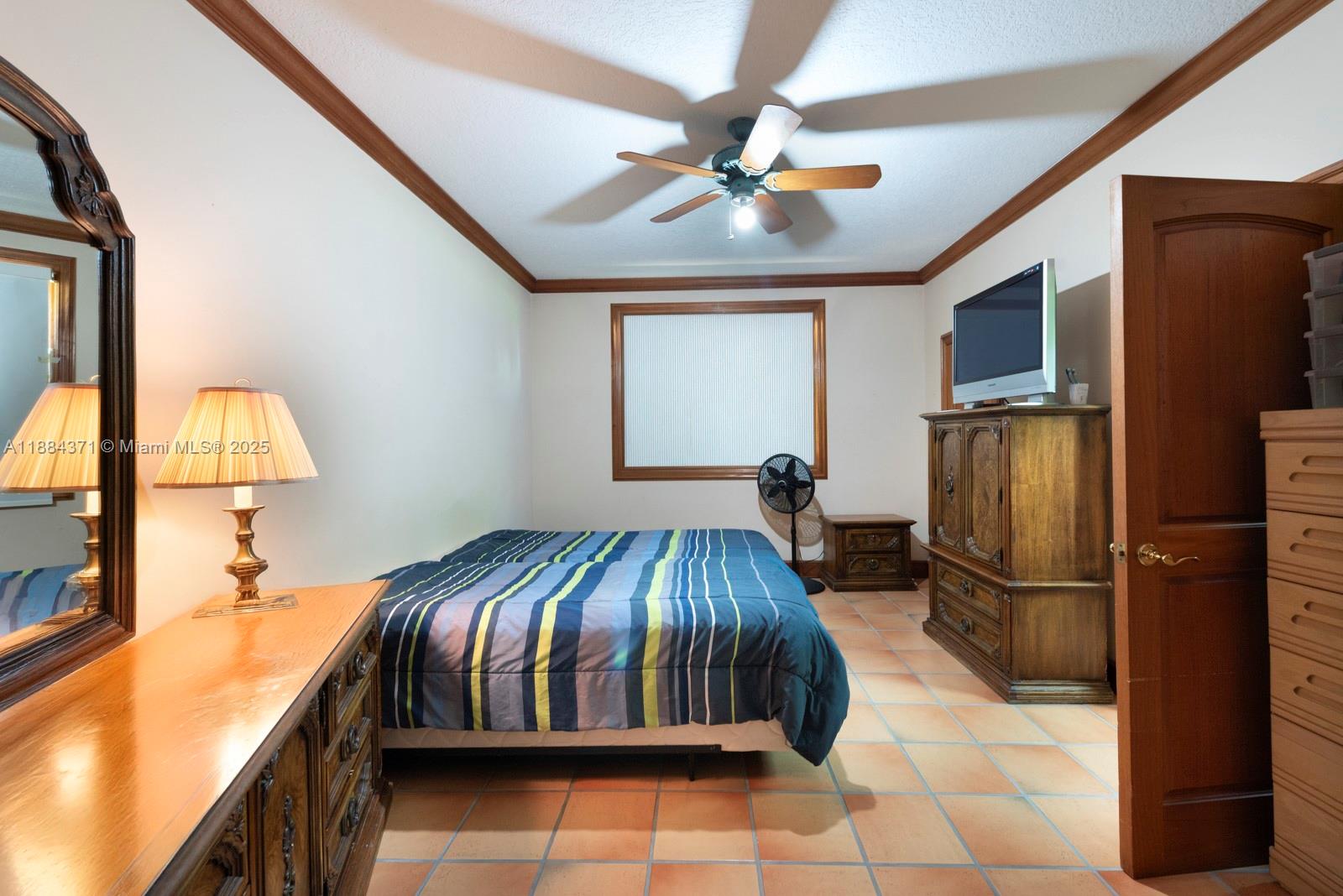 9360 Southwest 66th Street Miami, FL 33173 - Photo 48 of 64 a bedroom with a bed and a chandelier