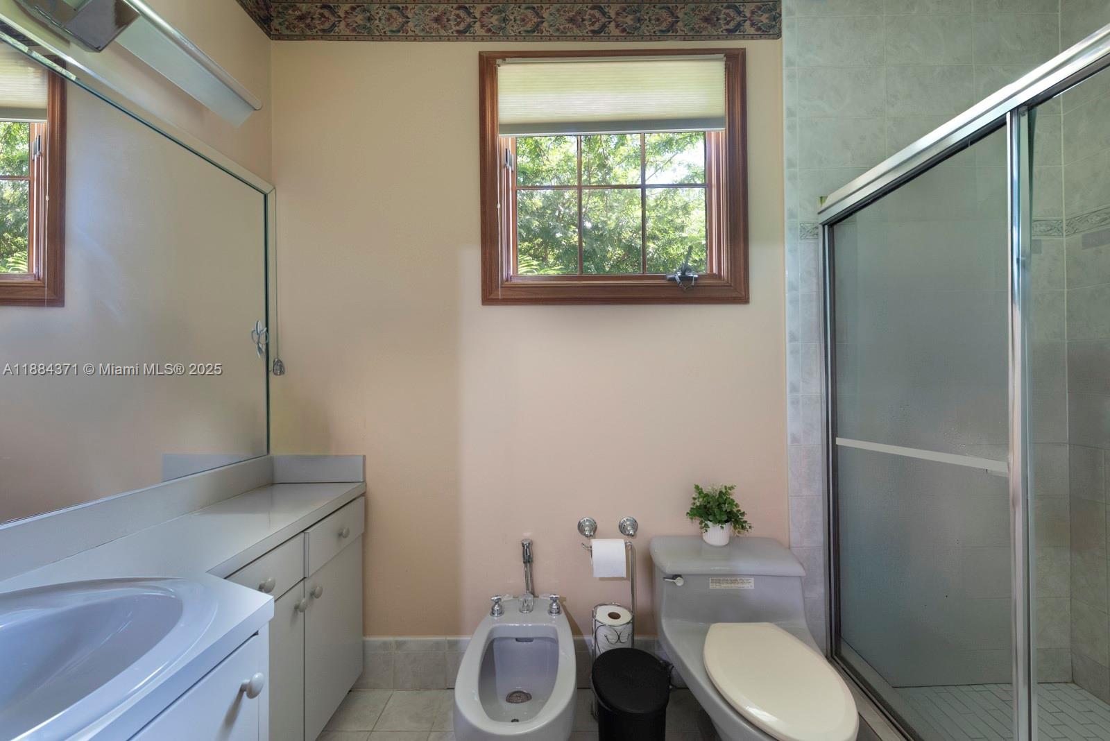 9360 Southwest 66th Street Miami, FL 33173 - Photo 49 of 64 a white toilet sitting next to a bathroom sink and vanity