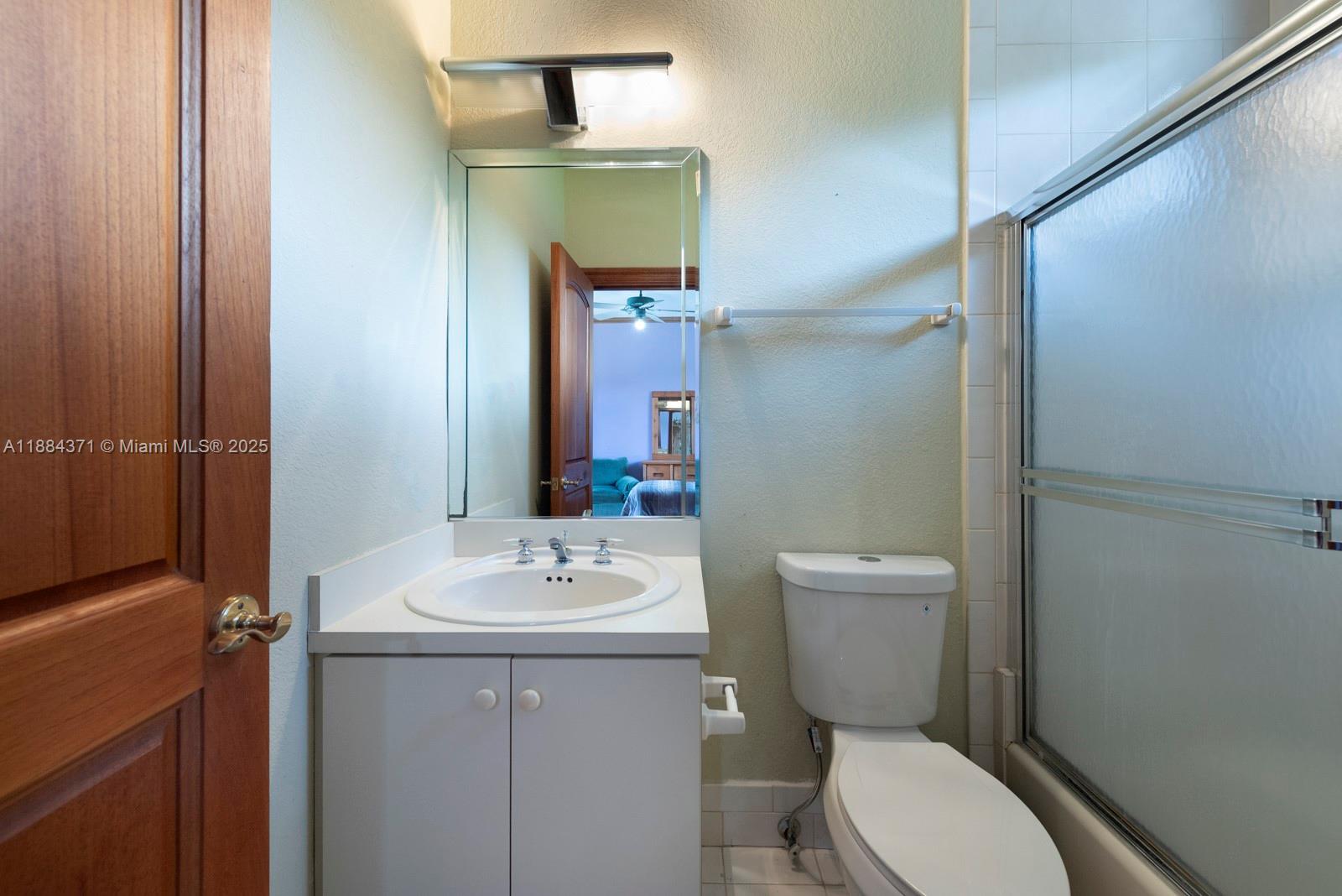 9360 Southwest 66th Street Miami, FL 33173 - Photo 53 of 64 a bathroom with a toilet a sink and mirror