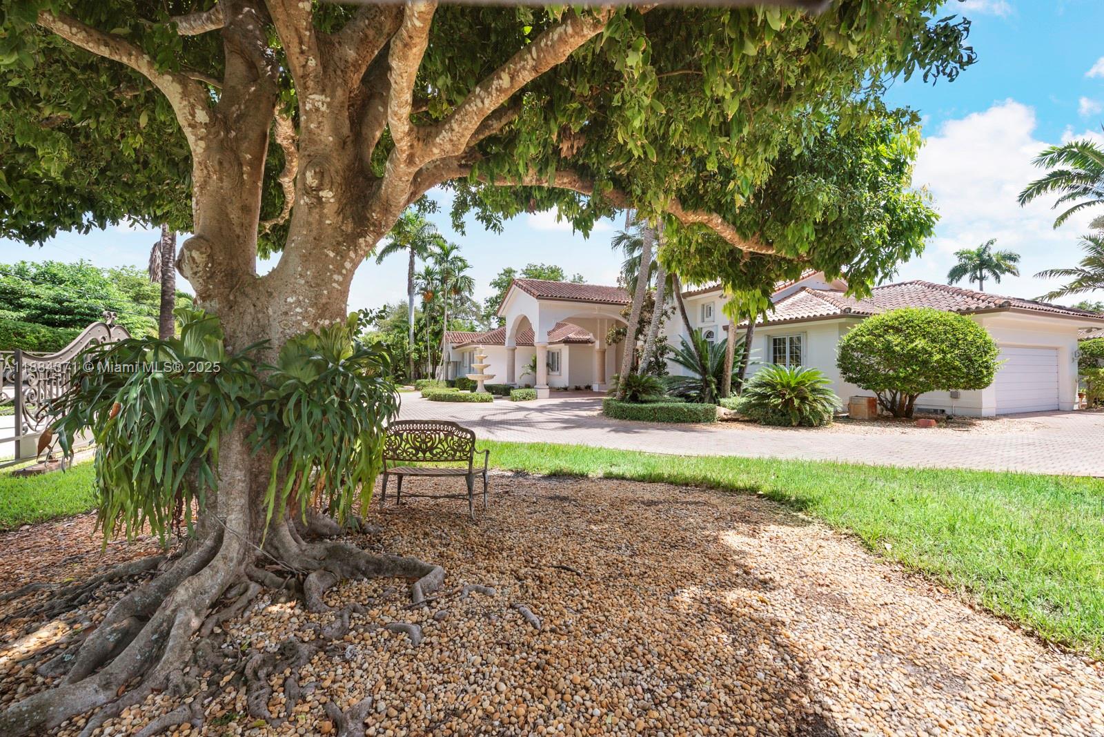 9360 Southwest 66th Street Miami, FL 33173 - Photo 9 of 64 a view of backyard with table and chairs and a large tree