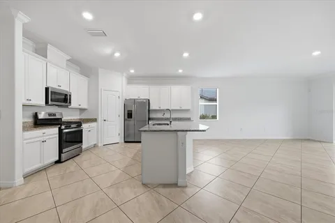 a view of kitchen with kitchen island and stainless steel appliances