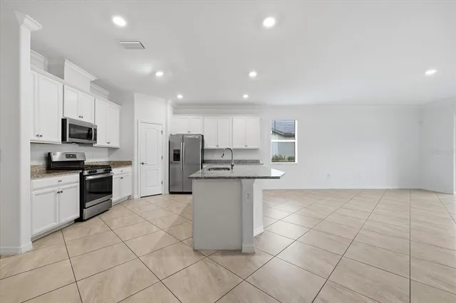 a view of kitchen with kitchen island and stainless steel appliances