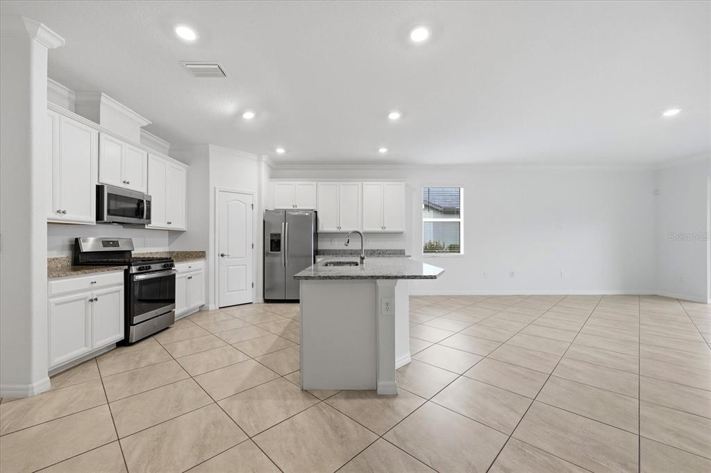 2607 Avolet Court Lakewood Ranch, FL 34211 - Photo 12 of 56 a kitchen with stainless steel appliances granite countertop a refrigerator sink and cabinets