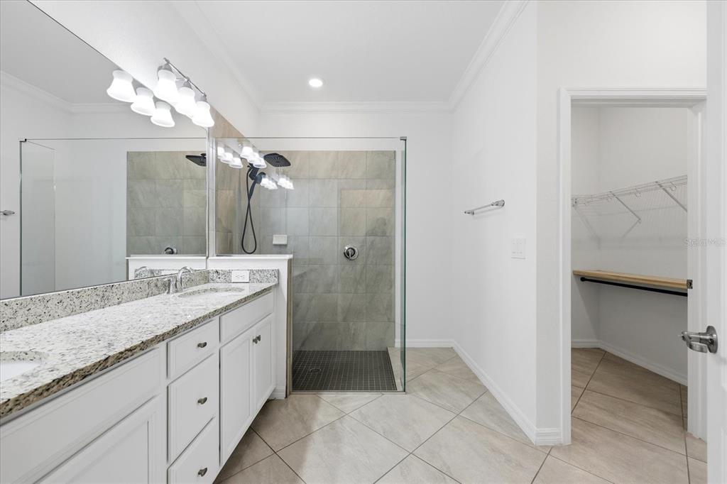 2607 Avolet Court Lakewood Ranch, FL 34211 - Photo 21 of 56 a bathroom with a granite countertop sink a mirror and a shower