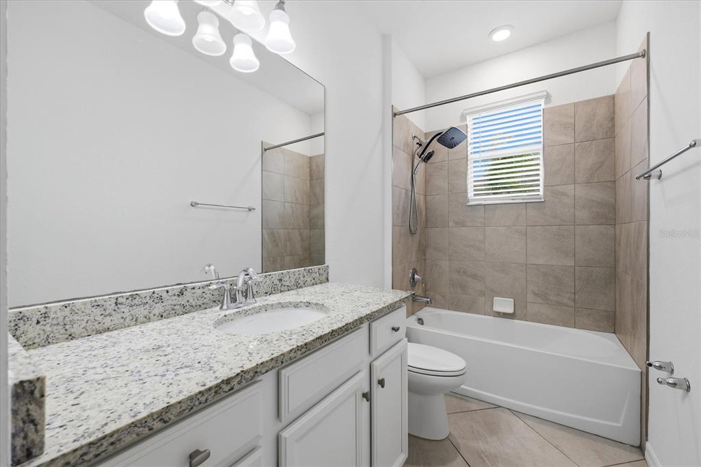 2607 Avolet Court Lakewood Ranch, FL 34211 - Photo 24 of 56 a bathroom with a granite countertop sink a toilet and bathtub