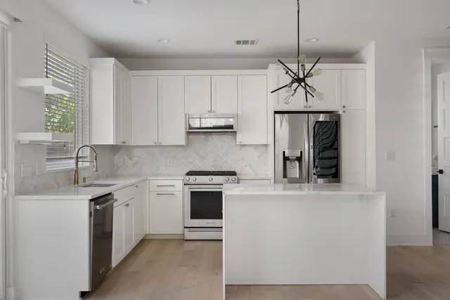 a kitchen with stainless steel appliances a sink stove and refrigerator