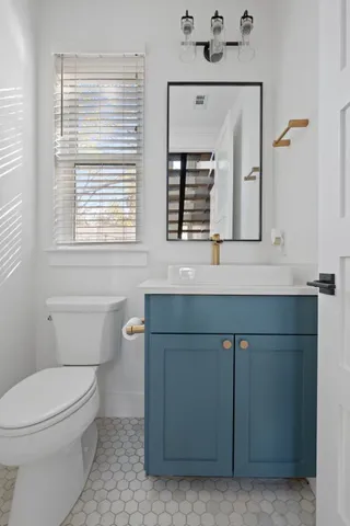 a bathroom with a toilet sink and mirror