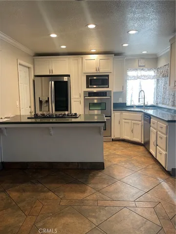 a kitchen with stainless steel appliances a refrigerator and a stove top oven