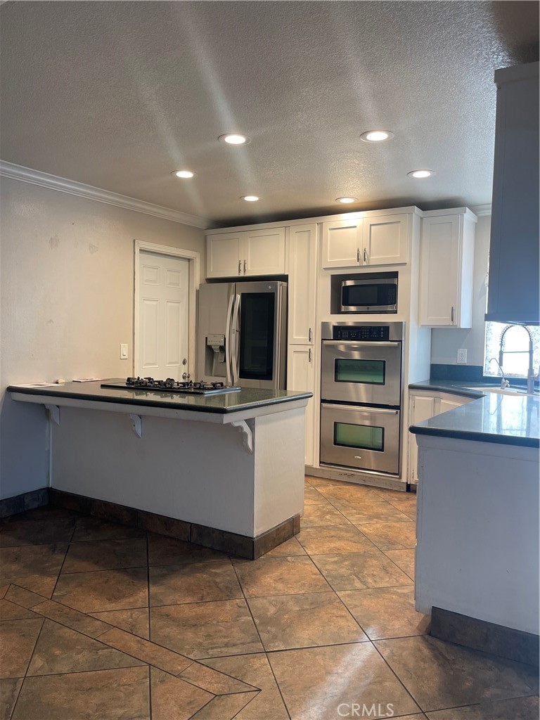 26380 Erwin Court Hemet, CA 92544 - Photo 4 of 12 a kitchen with stainless steel appliances a refrigerator and a stove top oven