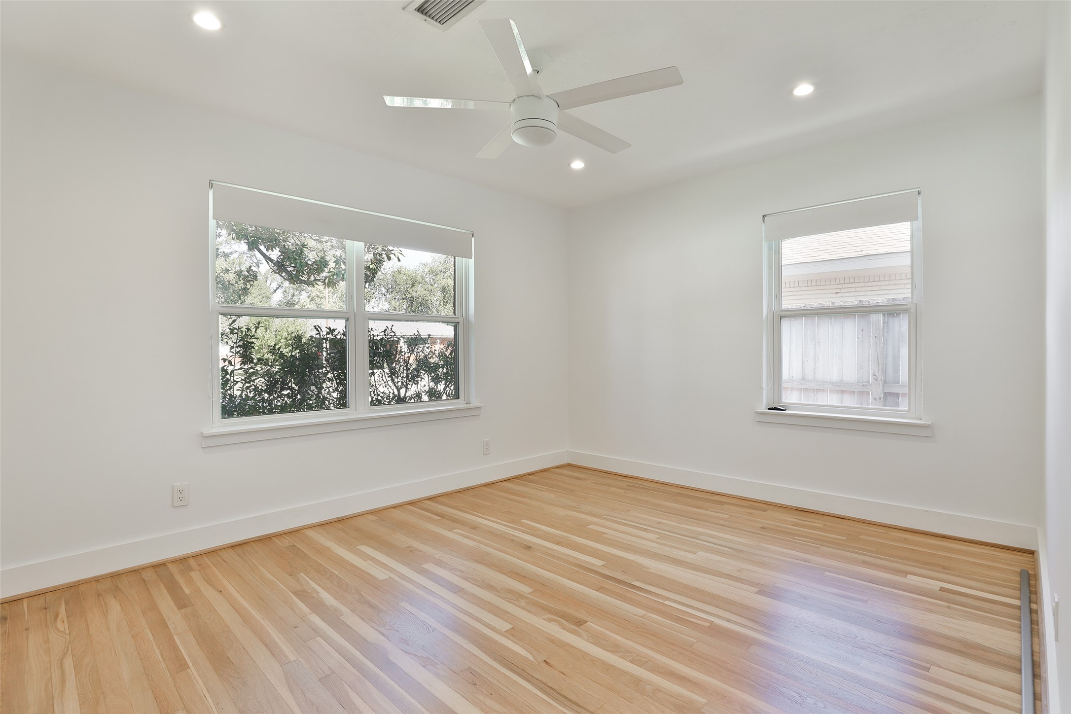 4613 Libbey Drive Houston, TX 77092 - Photo 11 of 26 an empty room with wooden floor chandelier fan and windows