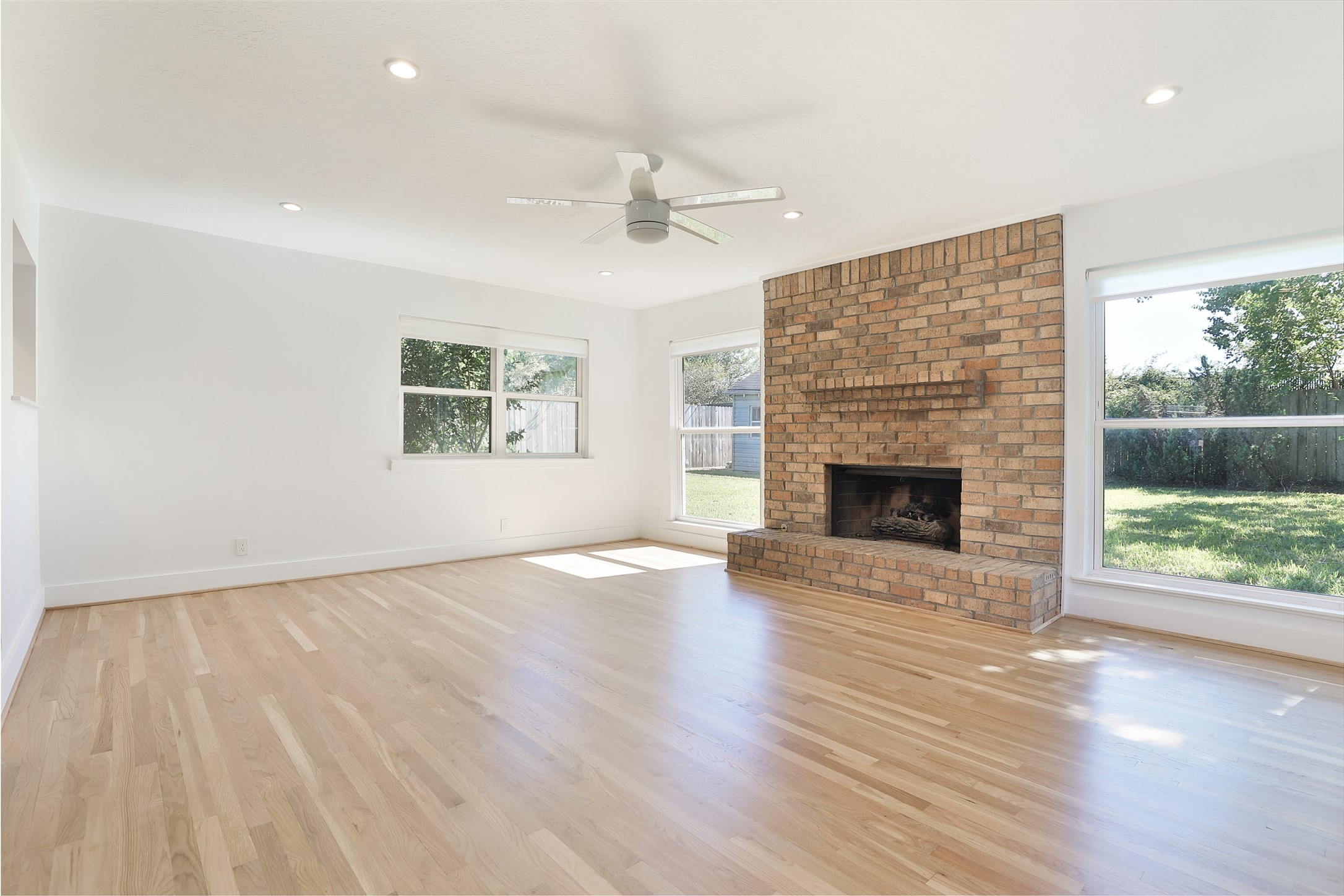 4613 Libbey Drive Houston, TX 77092 - Photo 10 of 26 an empty room with wooden floor fireplace windows and wooden floor