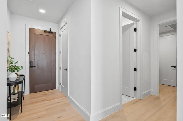a view of a hallway with wooden floor and closet area
