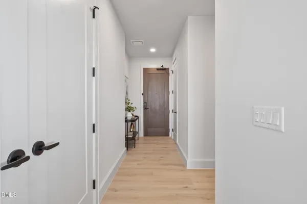 a view of a hallway with wooden floor and closet
