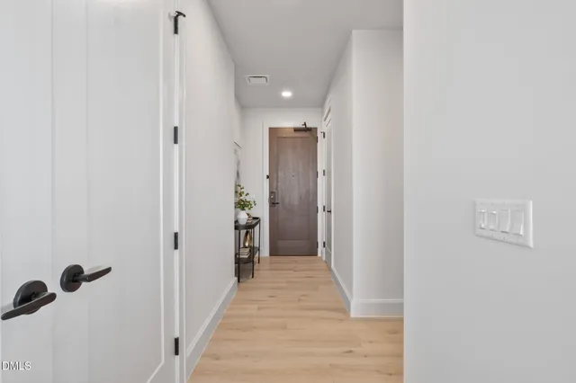 a view of a hallway with wooden floor and closet