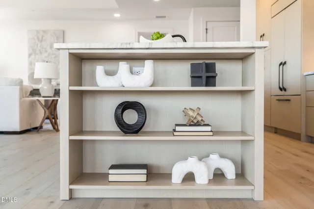 a kitchen with a dining table chairs wooden floor appliances and cabinets