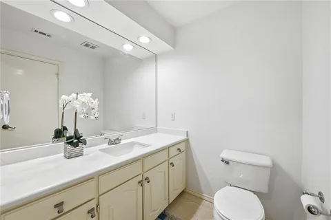 a bathroom with a toilet a sink and mirror