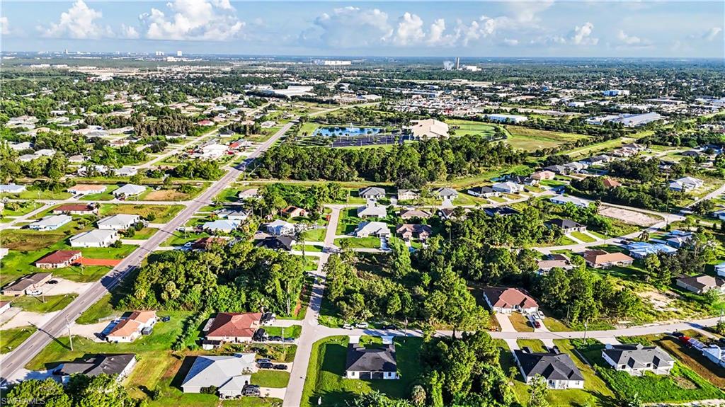 2239 Armour Road Lehigh Acres, FL 33973 - Photo 19 of 24 Aerial view showcasing a sprawling residential community featuring generous lot sizes, mature tree-lined properties, manicured green spaces, and well-distributed homes with varied architectural styles