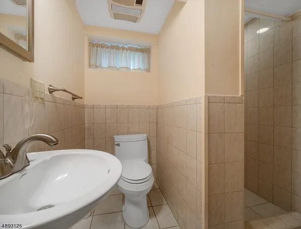 a bathroom with a sink a toilet and mirror