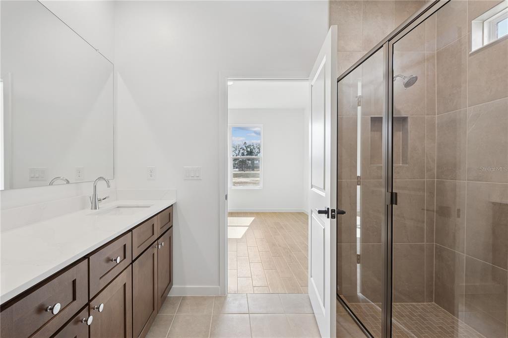 4521 Northwest 37th St Road Ocala, FL 34482 - Photo 13 of 14 a bathroom with a granite countertop sink mirror and shower