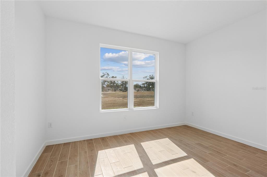 4521 Northwest 37th St Road Ocala, FL 34482 - Photo 10 of 14 an empty room with wooden floor and windows