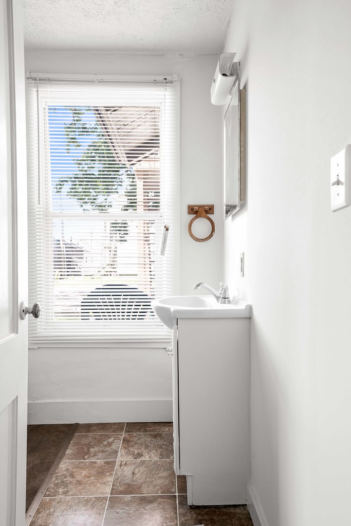 410 East Grove Street Bloomington, IL 61701 - Photo 13 of 25 a bathroom with a sink a mirror and a window
