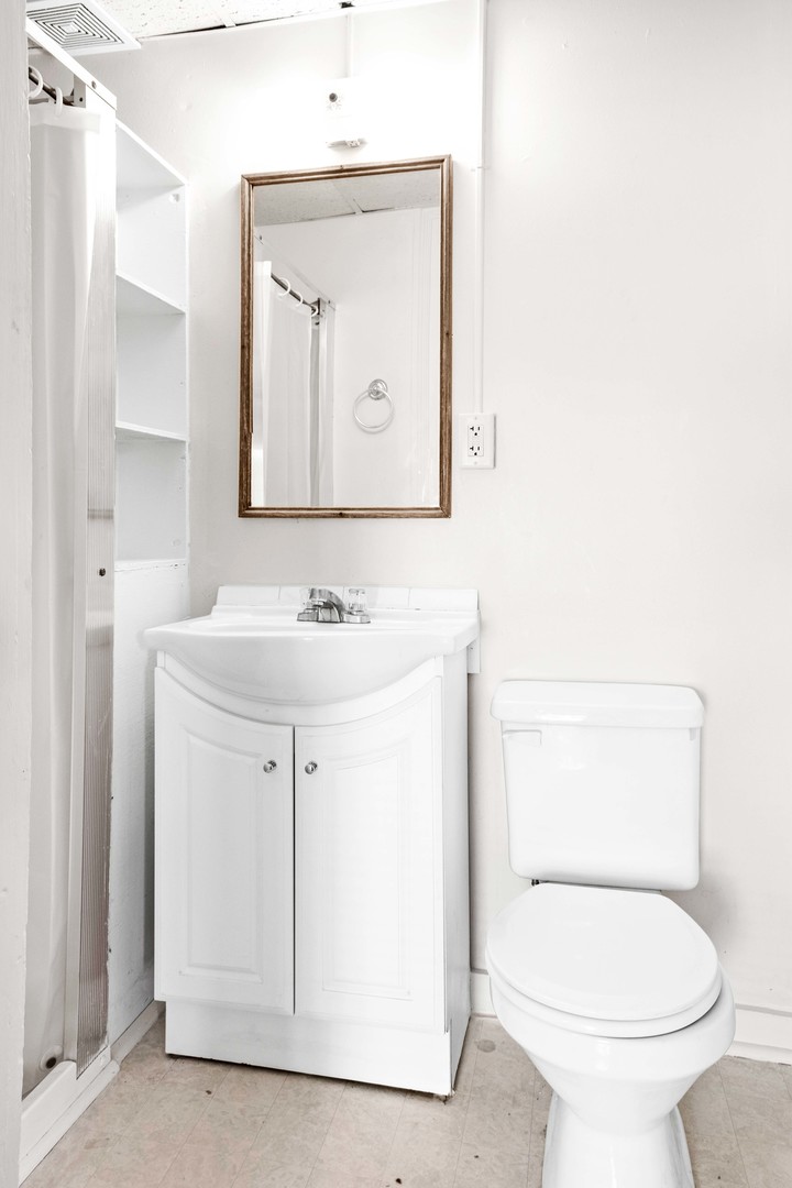 410 East Grove Street Bloomington, IL 61701 - Photo 23 of 25 a bathroom with a toilet sink and mirror