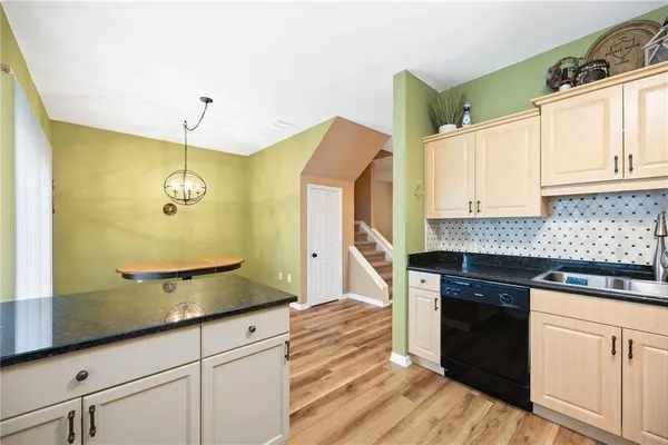 a kitchen with granite countertop cabinets a sink a window and stainless steel appliances