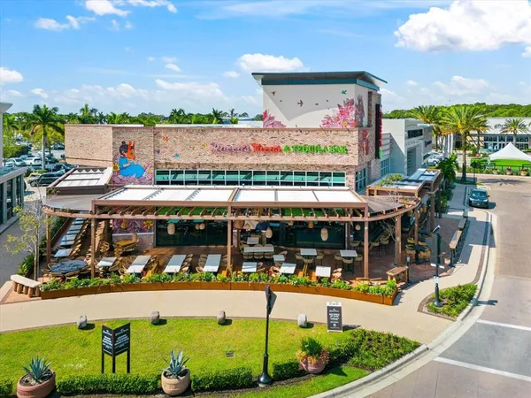 a view of sign board with flower plants and wooden fence