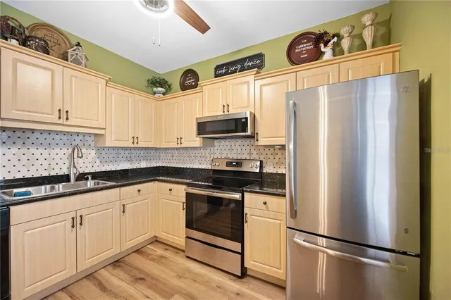 a kitchen with stainless steel appliances a refrigerator sink and microwave