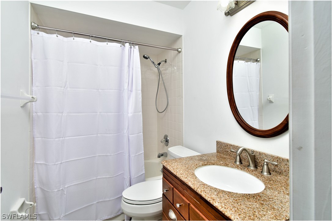13273 Heather Ridge Loop Fort Myers, FL 33966 - Photo 17 of 21 a bathroom with a granite countertop sink a toilet and a mirror