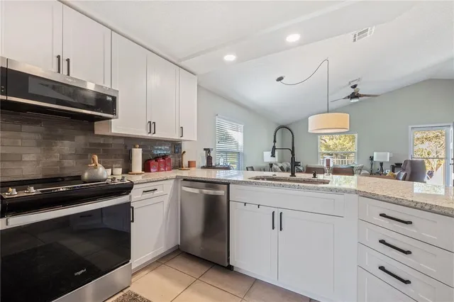 a kitchen with white cabinets and appliances