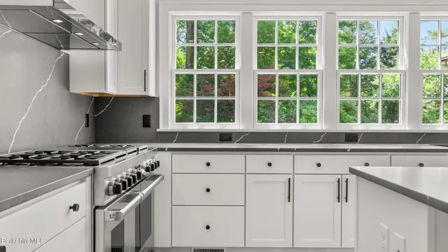 a kitchen with granite countertop white cabinets and a window
