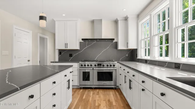 a kitchen with granite countertop a sink stove and cabinets