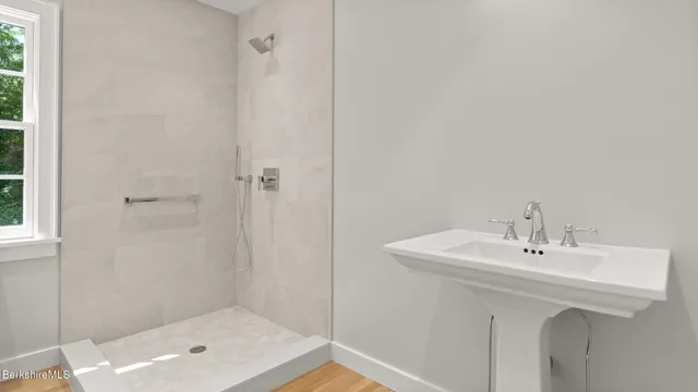 an empty room with wooden floor fireplace and windows