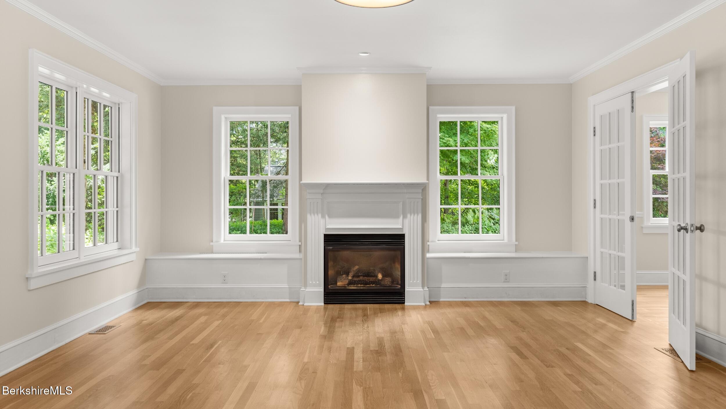 55 Main Street Stockbridge, MA 01262 - Photo 22 of 54 an empty room with wooden floor fireplace and windows