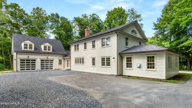 a view of a house with a small yard and wooden fence