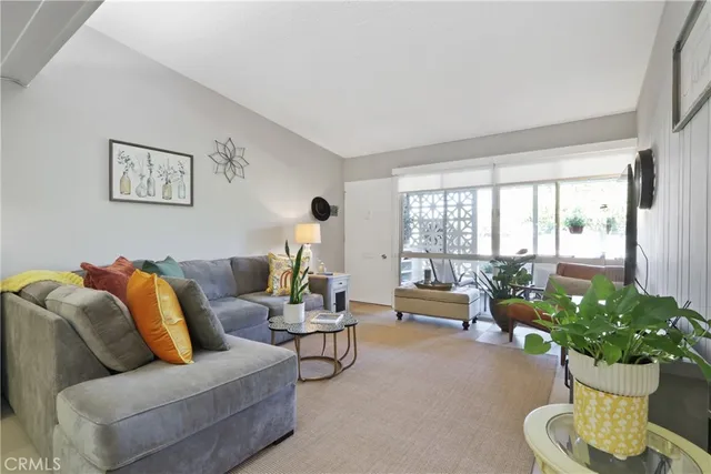 a living room with furniture potted plant and a large window