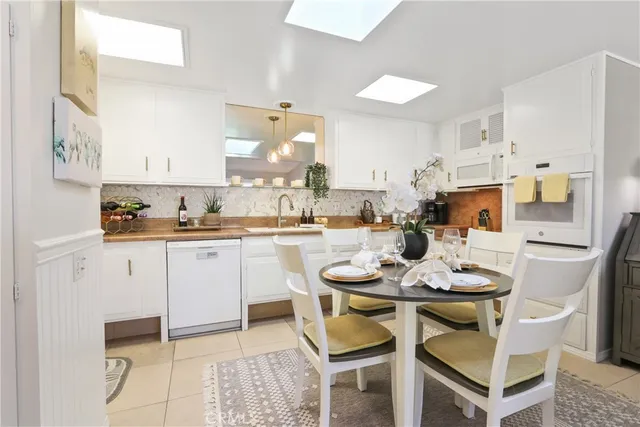 a kitchen with a dining table chairs and white appliances