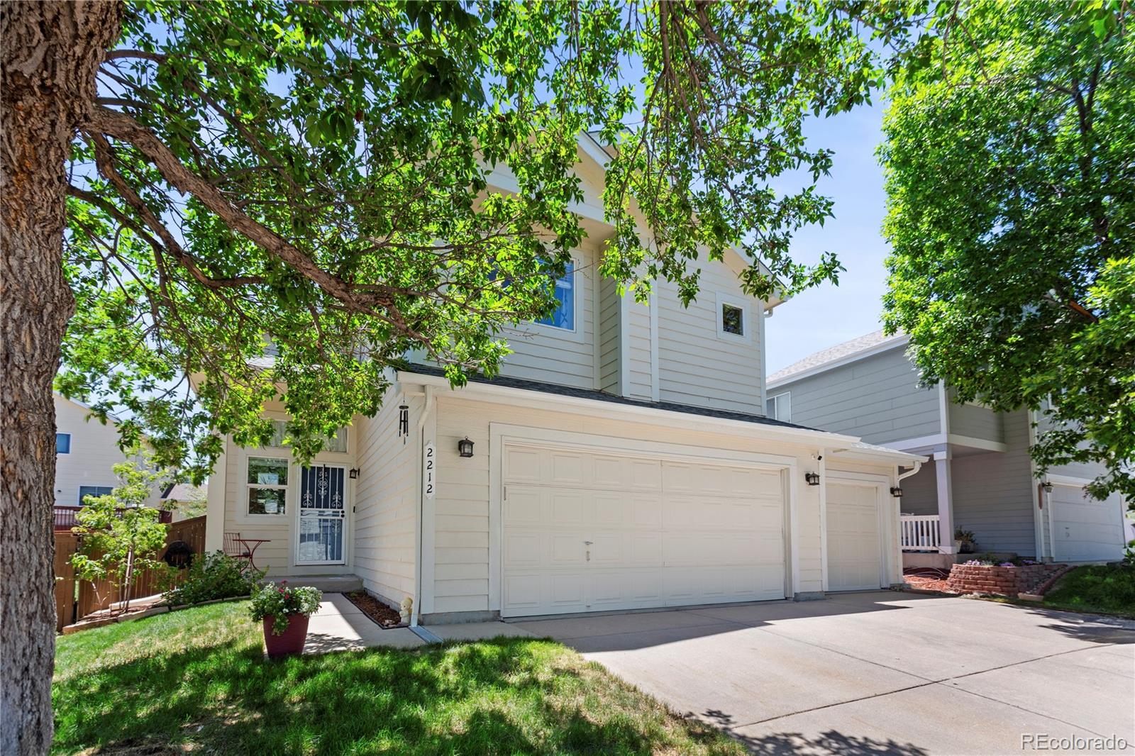 2212 Hyacinth Road Littleton, CO 80129 - Photo 1 of 44 a view of a white house with a tree and plants